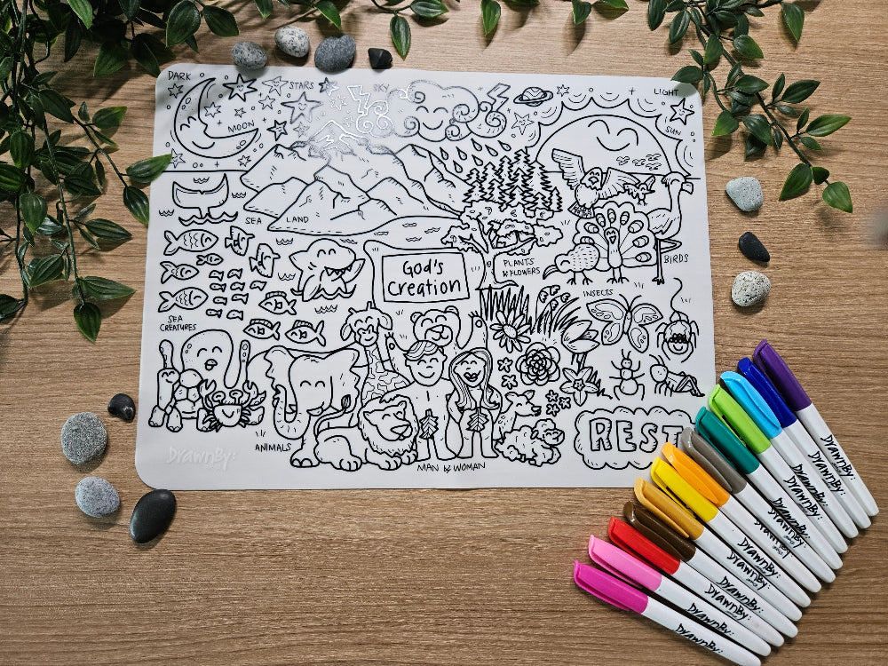 DrawnBy: God's Creation Bible Story Coloring Mat  with illustrations of God's Creation and markers on a wooden surface with leaves and stones.