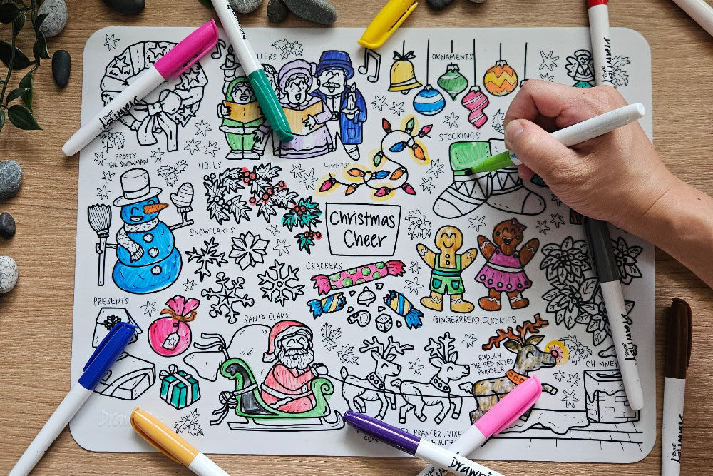 Colouring the DrawnBy: Christmas Cheer Mat with markers on a wooden table