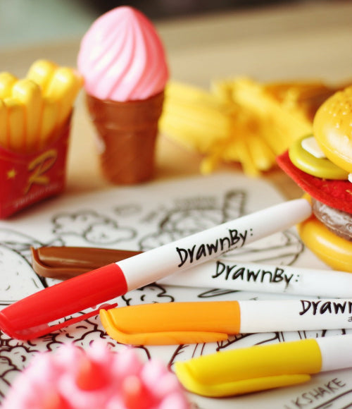 A picture of toy food and markers on DrawnBy:'s Junk Out mat